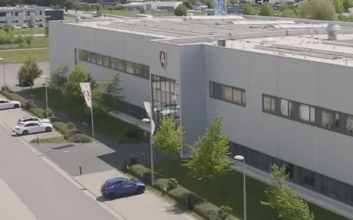 Außenansicht des ARTUS Firmengebäudes mit Parkplatz und Grünflächen.